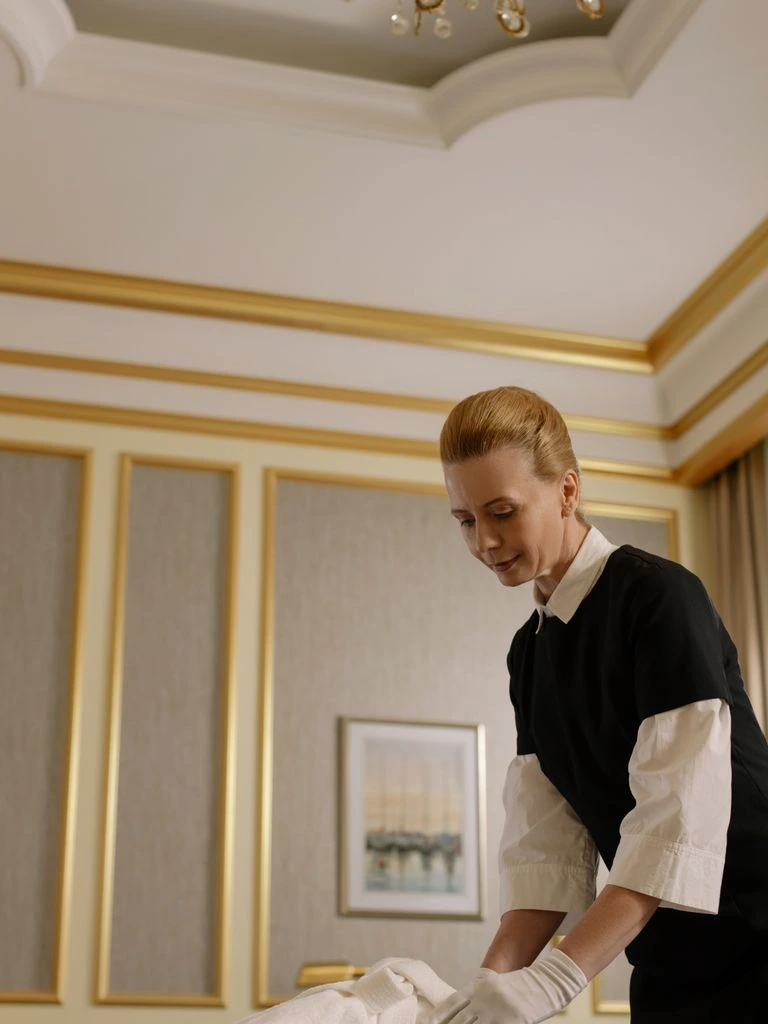 A housekeeping cart with freshly pressed linens in a quiet guest-room corridor.